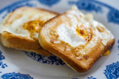  Tabakta yumurta ekmeği, doğal ışıkla fotoğraflanmış. Yumurtalı ve tereyağlı Fransız tostu. Ekmekli kahvaltı. İngiliz kahvaltısı. Yumurtalı sağlıklı kahvaltı. Lezzetli kahvaltı.
