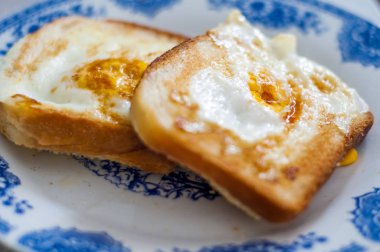  Tabakta yumurta ekmeği, doğal ışıkla fotoğraflanmış. Yumurtalı ve tereyağlı Fransız tostu. Ekmekli kahvaltı. İngiliz kahvaltısı. Yumurtalı sağlıklı kahvaltı.