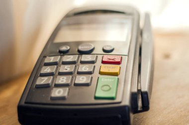 Kredi kartı - pos terminal tutan işadamı ile ödeme. Ödeme kartı terminal bir bankada. Elektronik ödeme kavramı. Renkli görüntü Pos terminali