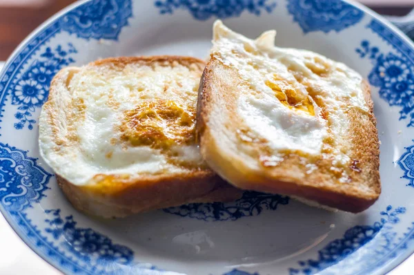  Tabakta yumurta ekmeği, doğal ışıkla fotoğraflanmış. Yumurtalı ve tereyağlı Fransız tostu. Ekmekli kahvaltı. İngiliz kahvaltısı. Yumurtalı sağlıklı kahvaltı.