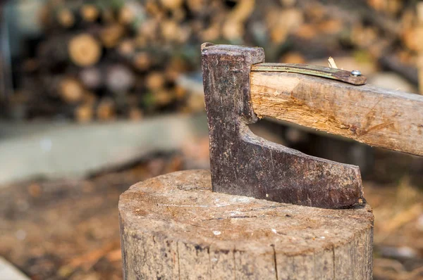 balta ile odun keserken. Ahşap bir günlüğüne sıkışmış balta