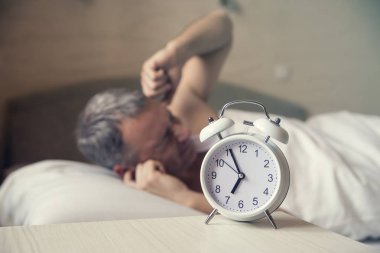 Uyuyan adam çalar saat sabah erken tarafından rahatsız. Kızgın adam yatakta bir gürültü ile uyandı. Waked. Bir çalar saat sabah 7 de dönüm yatakta yatan adam