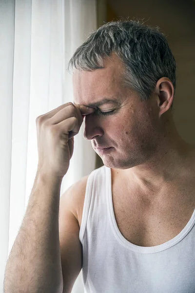 Hombre mirando a través de la ventana mirando preocupado, deprimido, reflexivo y solitario sufrimiento depresión en la presión de trabajo o problemas personales concepto con espacio de copia — Foto de Stock