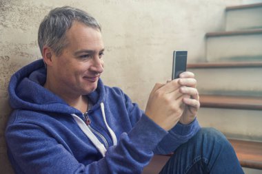 insanlar, Stil, teknoloji ve yaşam tarzı - smartphone içinde ev merdivenlerde oturan olgun adamla. Internet için vaktinizi yakışıklı adam