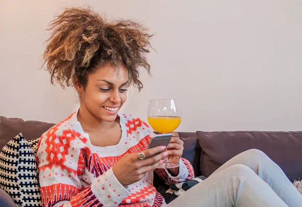 Afrikanisch-amerikanische Frau, die ihm eine SMS aufs Handy schickt - schwarze Menschen, die ihm eine schöne Nachricht schicken. attraktive junge Frau mit Smartphone und Lächeln — Stockfoto
