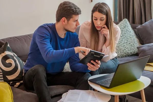 Man and woman working together at home. Couple Working From Home Looking At Personal Finances. Busy couple working at the office counting financial data