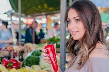 Bir kadın elinde biber taşır. kadın markette ölçmek için taze sebze seçme