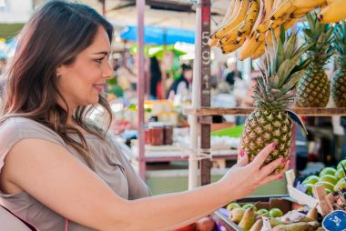 Çekici kadın yeşil pazarda alışveriş. Portre portre alacak, meyve, seçme güzel ve genç birbayan ananas. Pozitif yüz ifade duygu duygu sağlıklı yaşam tarzı