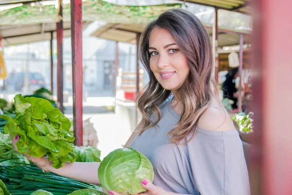 Woman buying fresh organic vegetables at street market. Young woman buying vegetables at the green market. — Stock Photo, Image