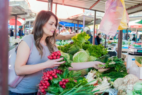 Mujer comprando frutas y verduras en el mercado local de alimentos. Puesto de mercado con variedad de verduras orgánicas . —  Fotos de Stock