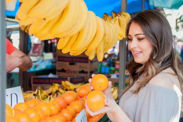 Young woman buying fresh fruit at farmer's market. Beautiful woman buying fruits in market. Young woman on the market — Stock Photo, Image