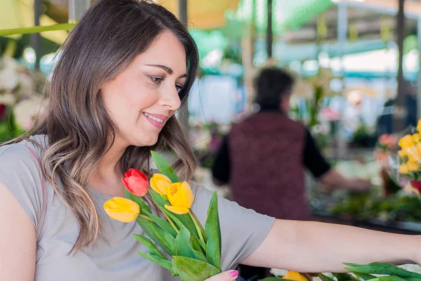 Woman with tulips. Beautiful woman with flowers. delicate and beautiful woman smelling tulips