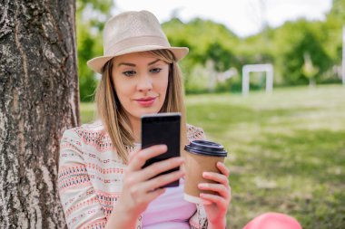 En iyi kahve! Kahve tutarak ve konuşan genç kız gülümseyerek