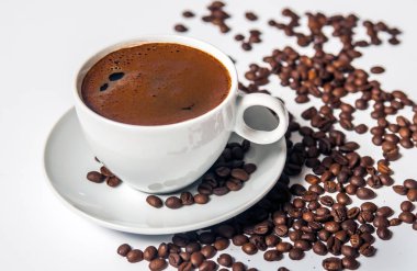 Beyaz arka planda kahve fincanı ve fasulye.. 