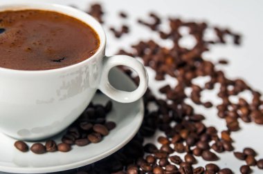 Beyaz arka planda kahve fincanı ve fasulye.. 