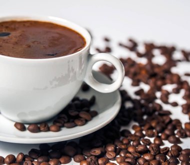 Beyaz arka planda kahve fincanı ve fasulye.. 