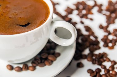 Beyaz arka planda kahve fincanı ve fasulye.. 