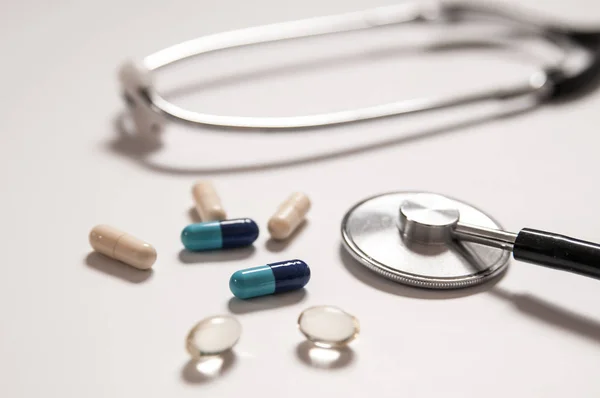 Stethoscope on white background with mix pills isolated — Stock Photo, Image