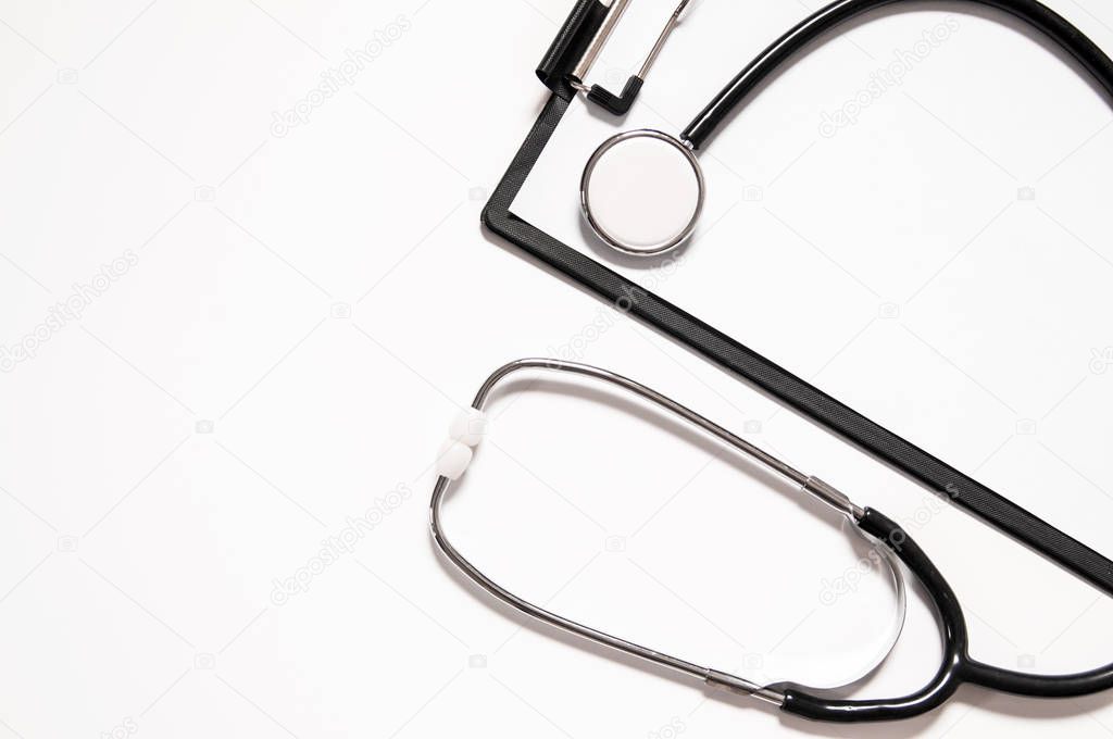 Stethoscope and blank clipboard isolated on white