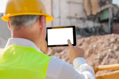 Sarı hardhat dijital tablet inşaat alanında, arkadan görünüm kullanma inşaat mühendisi portresi 