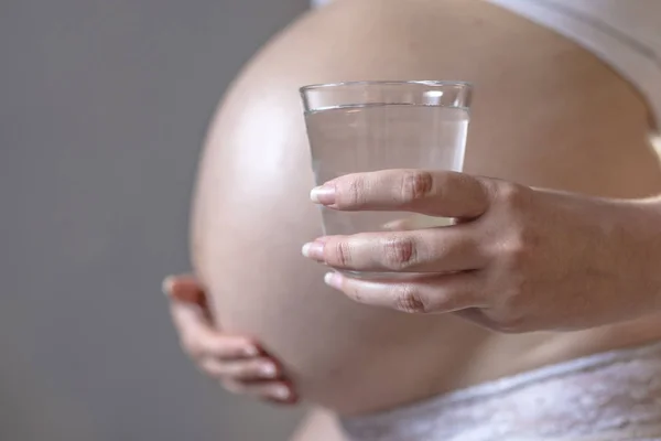 Mulher grávida e copo de água — Fotografia de Stock