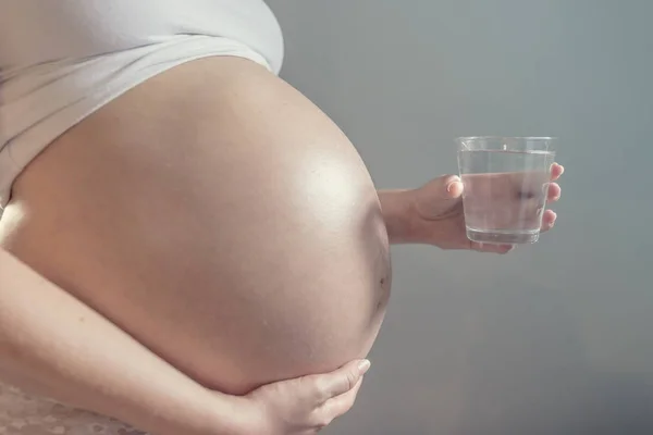 Těhotná žena a sklenicí vody — Stock fotografie