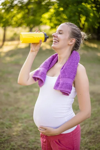 Gravid kvinna anläggning flaska — Stockfoto