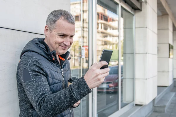 街で携帯電話を使用して幸せな成熟した男 — ストック写真