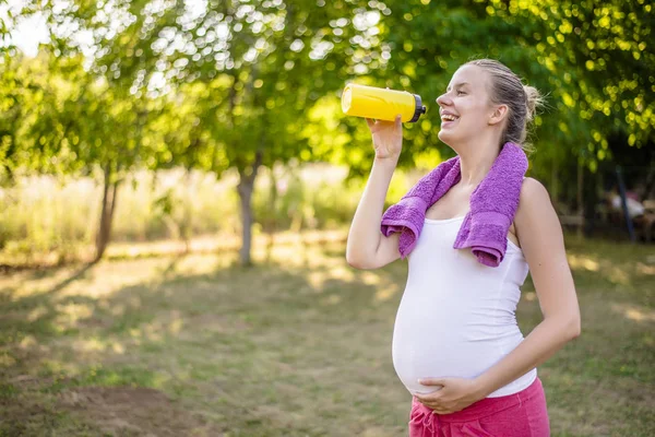 Gravid kvinna avkopplande i parken — Stockfoto