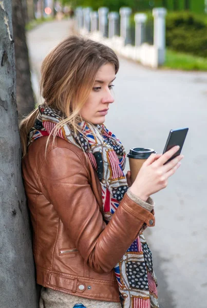 Женщина смотрит на смартфон — стоковое фото