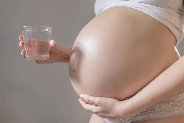 Mulher grávida e copo de água — Fotografia de Stock