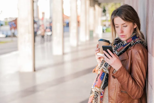 Молодая женщина с помощью своего смартфона — стоковое фото