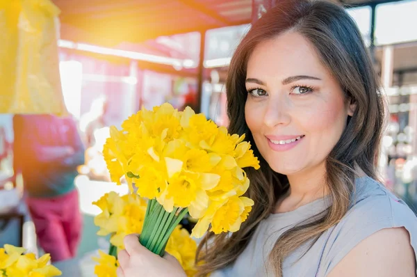 Женщина наслаждается цветами на цветочном рынке — стоковое фото