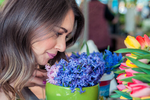 young pretty woman with spring flowers bouquet. Woman smelling bouquet of hyacinth