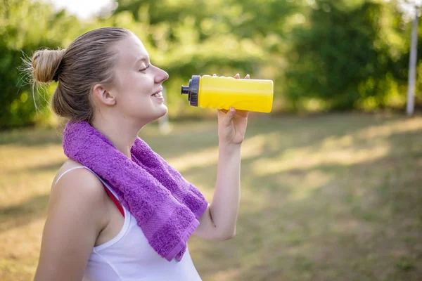 Беременная женщина пьет воду после фитнеса . — стоковое фото