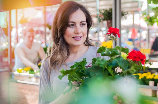 Mujer con flores de geranio — Foto de Stock