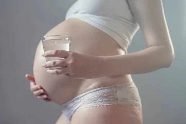 Gravid kvinna och glas vatten — Stockfoto