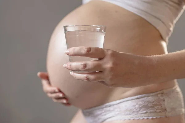 Mulher grávida e copo de água — Fotografia de Stock