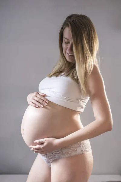 Mujer embarazada en ropa interior blanca . — Foto de Stock
