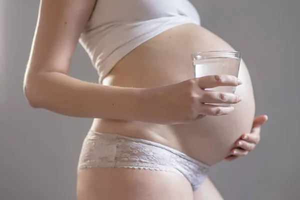 Mujer embarazada y vaso de agua —  Fotos de Stock