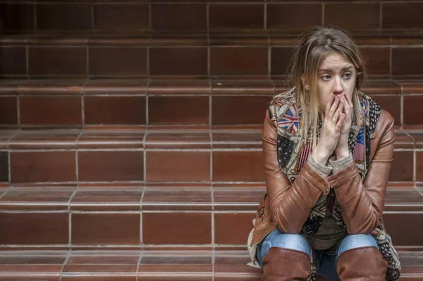 Smutna dziewczyna zamyśleniu siedzący na ulicy — Zdjęcie stockowe