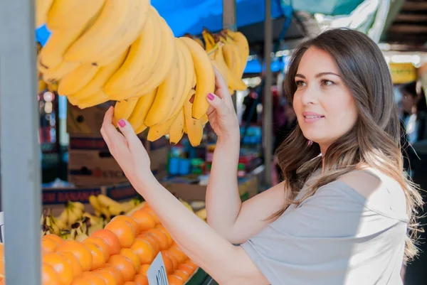 Mujer joven comprando plátanos —  Fotos de Stock