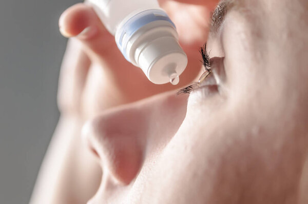 young woman applying eye drop