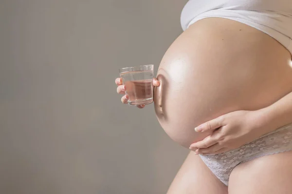 Mulher grávida e copo de água — Fotografia de Stock