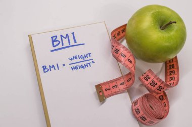 BMI body mass index formula in a notepad. Measuring tape, notepad and green apple clipart