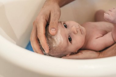 Hijyen ve bakım bebek için. Baba banyo oğul beyaz küçük plastik bebek küvet içinde