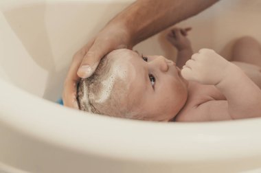 Hijyen ve bakım bebek için. Baba banyo oğul beyaz küçük plastik bebek küvet içinde