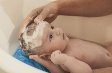 Hijyen ve bakım bebek için. Baba banyo oğul beyaz küçük plastik bebek küvet içinde