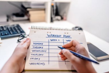 Portre erkek el egzersiz planı damalı not defterinde yazıyor. Planlama ve yönetim kavramı 
