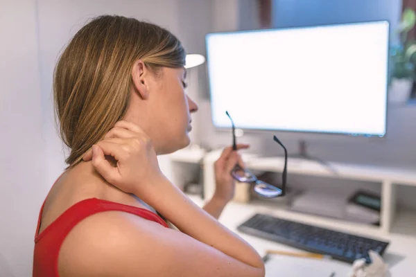 工作时颈部疼痛 疲惫的女性办公室工作人员坐在办公桌前按摩她的脖子 — 图库照片